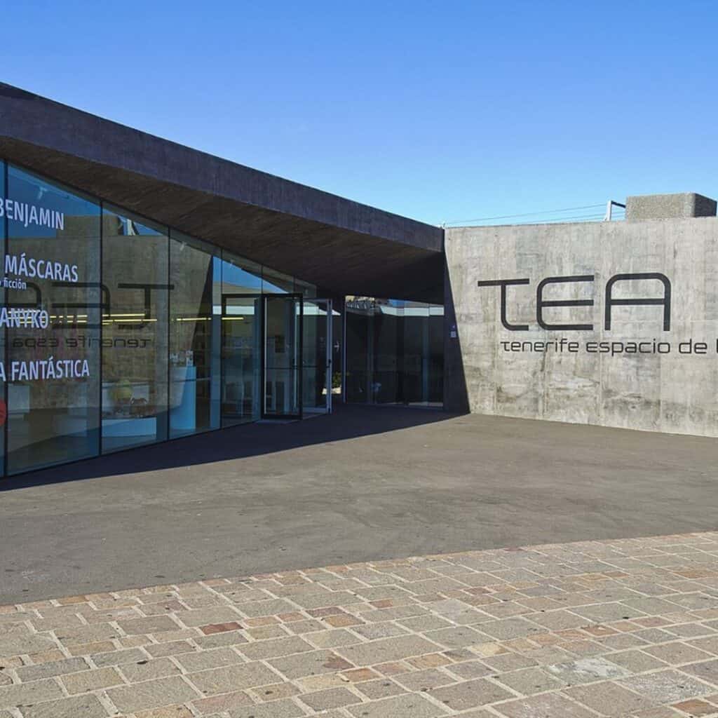 glass entrance to a modern building with a sign that says TEA
