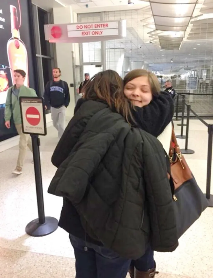 a mother hugging a child at the airport