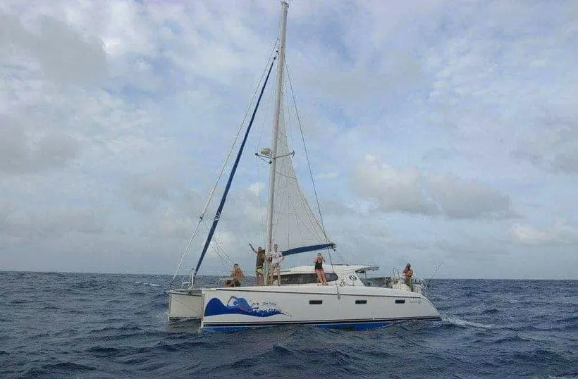 people on top of a catamaran on open sea in a bright day