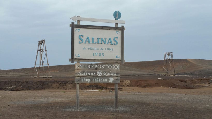 Plan out what to do in cape verde sal, wooden sign reading "Salinas de Pedra de Lume 1805" standing in wide open space of bare rolling hills