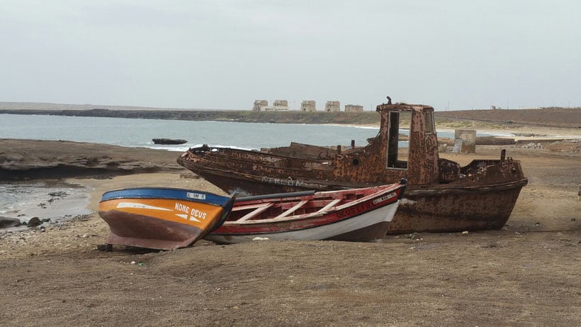 2 fishing boats and on an old boat on a beach