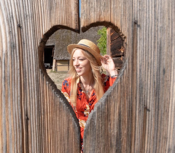 from a heart shaped whole, a woman with a hat posing