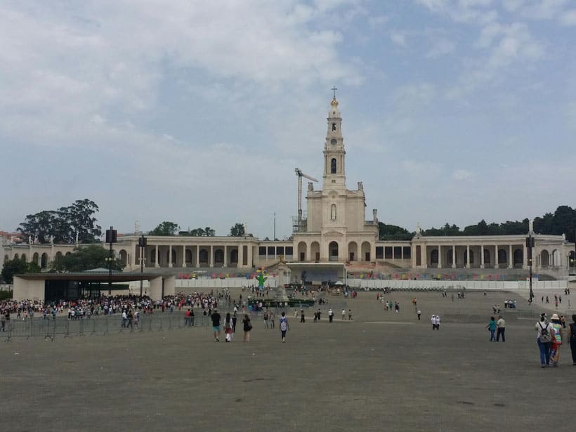 a facade of a plaza with people and a church