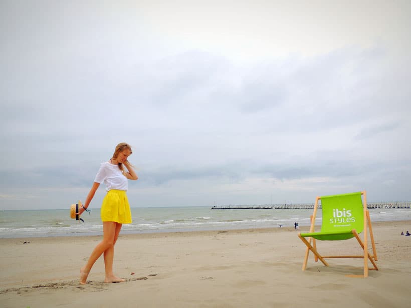 nieuwpoort beach, belgium, a woman on white short and yellow shorts on a beach with a green beach chair