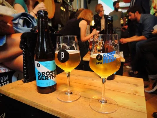 where to try the best brussels cuisine, table with two beer glasses filled with craft beer next to a beer bottle