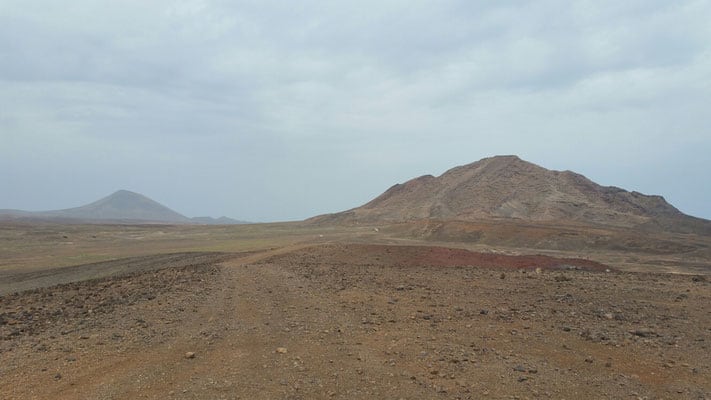 Discover what to see in sal cape verde, wide open plain with tall hills and mountains in the distance under a cloudy grey sky