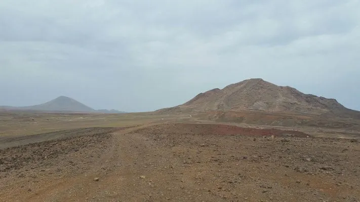 Discover what to see in sal cape verde, wide open plain with tall hills and mountains in the distance under a cloudy grey sky