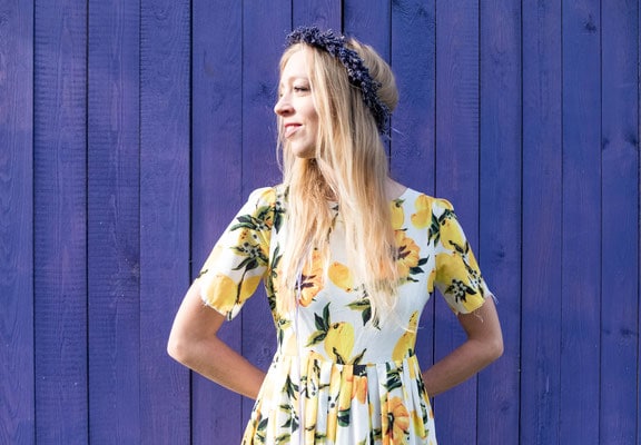 a woman looking sideways with a violet barn door as a background