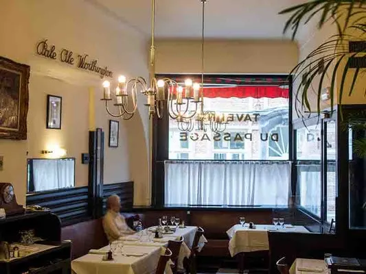what restaurants to try the best brussels cuisine, person sitting at a restaurant table by the window