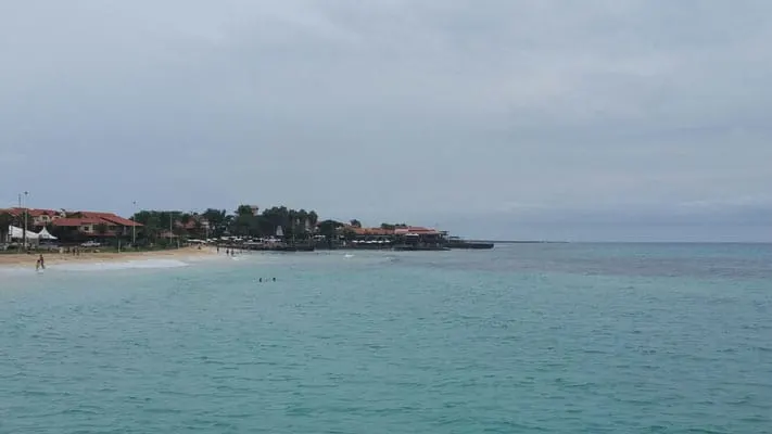 Enjoy the nightlife in sal, cape verde, busy beach side next to clear blue waters with trees and buildings in the distance