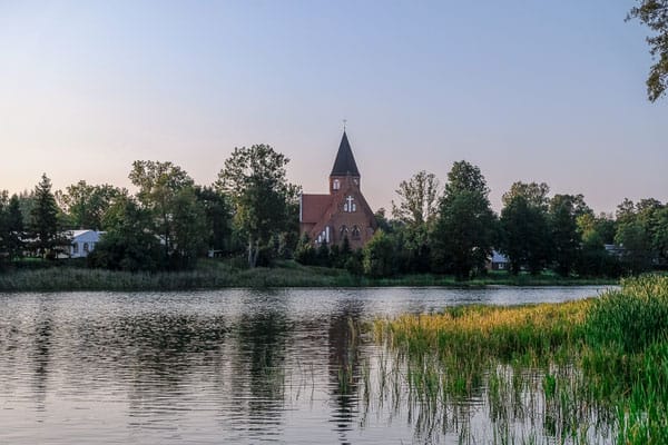 a view of a beautiful home from across the lake