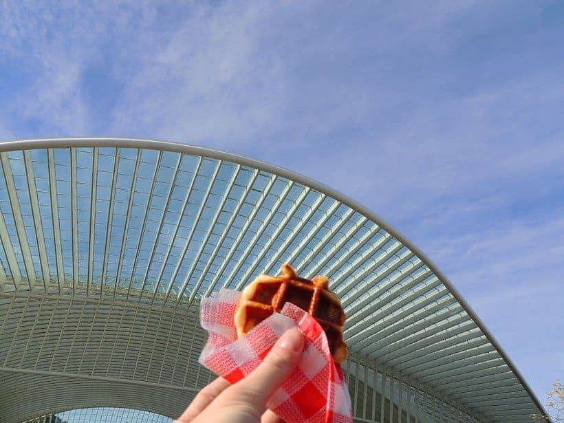 what to eat in liege belgium, eating a liege waffle outside the train station