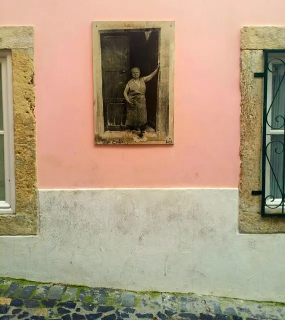 a street in lisbon with a pink wall
