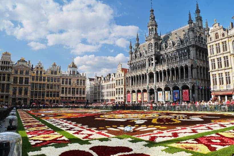 Head out on day trips from Luxembourg City in Belgium, colorful lawn with complex patterns being observed by crowds of people standing in the square outside of the grand place in Brussels