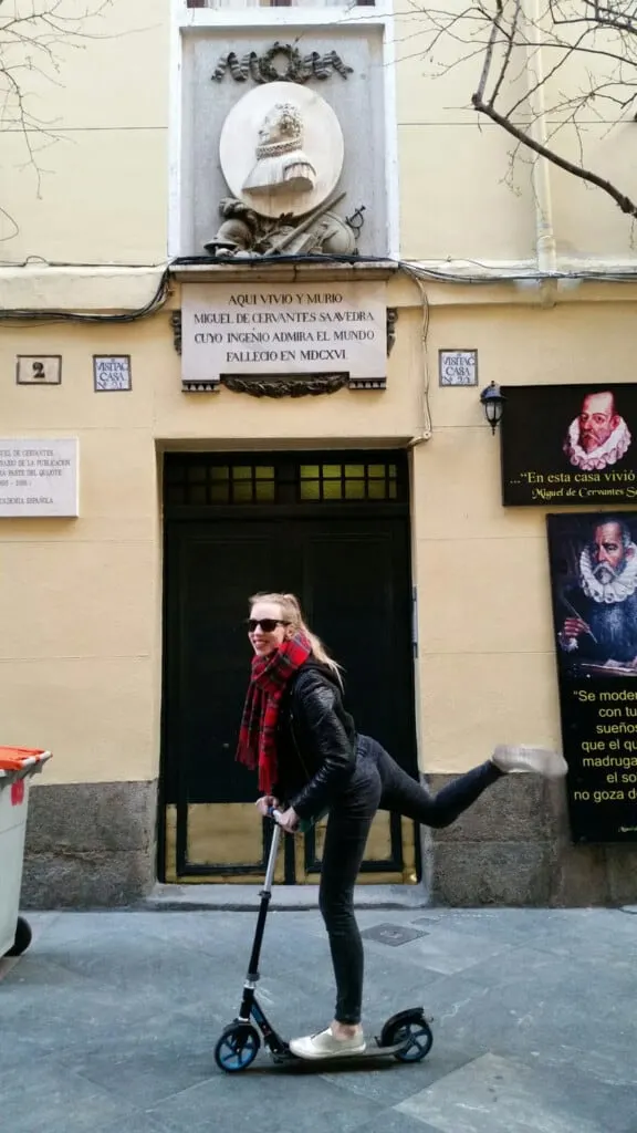 a woman on a scooter posing in front of a building, madrid-fun-tourism-city-travel-paulina-traveling-vaijando-turismo-ciudad-casa-cervantes-cervantes-house.jpg