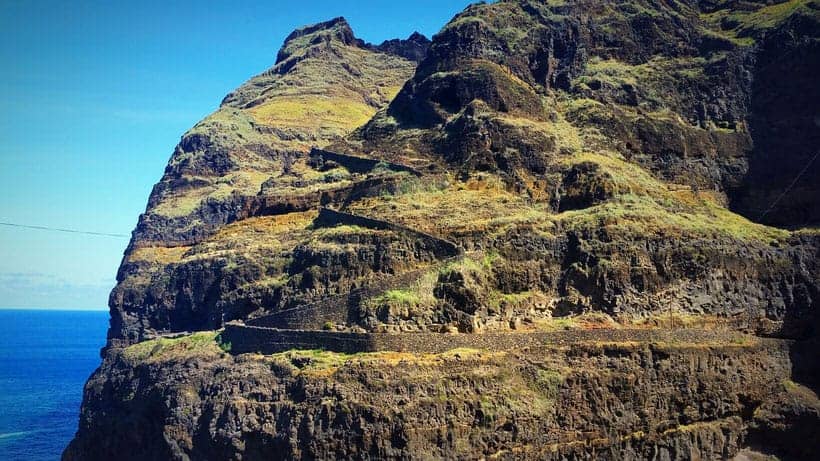 a part of a mountain with widing roads and the sea