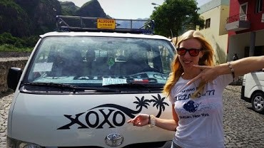 a girl posing with a car with a xoxo sign