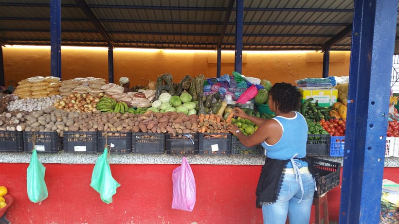 a woman arranging vegetables for sale at mindelo market, cape verde, cabo verde