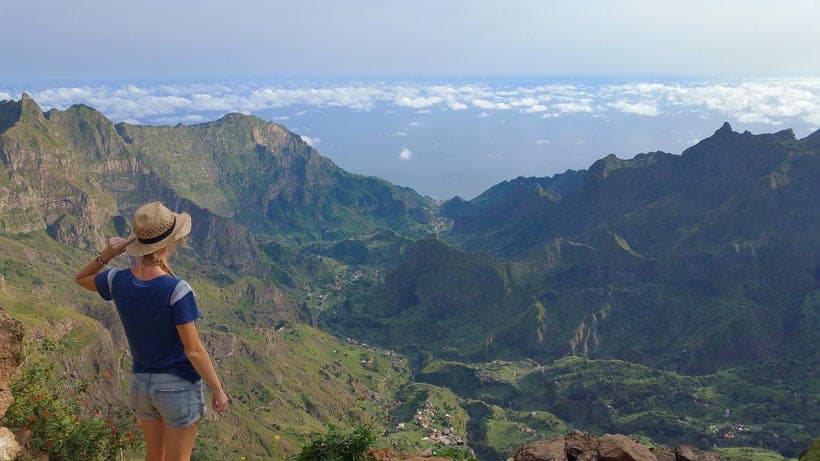 a woman looking over the cova crater view to paul view of the mountains and clouds