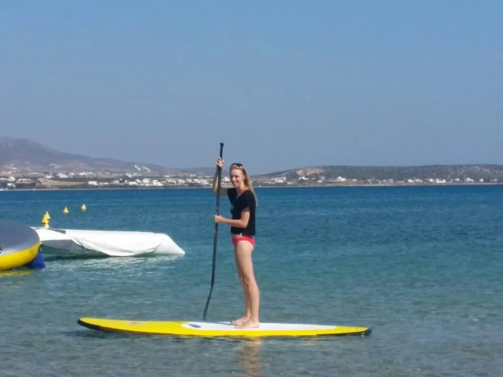 fun things to do in paros island, standing on a SUP kayak in the water