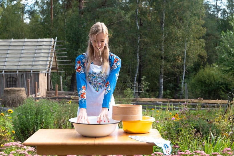 a woman putting her hands on a mall making bread in lipusz with a garden at the back