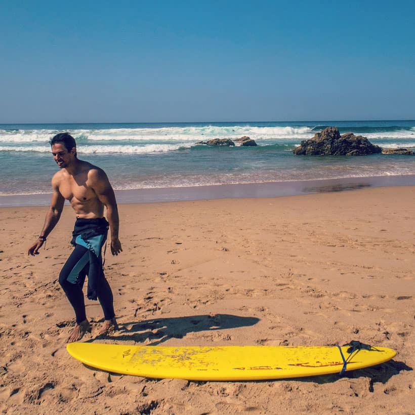 surfing on sandy beach Praia de São Rafael in albufeira portugal