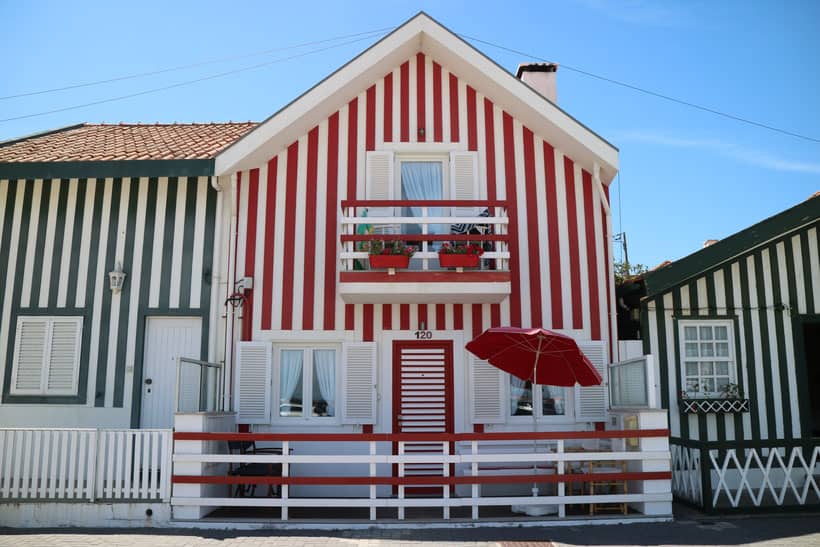 best places to visit in north portugal, small red, white and navy striped house with awnings