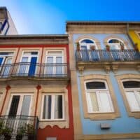 Cool Things To Do in Northern Portugal, view looking up at colorful buildings with awnings on a bright sunny day