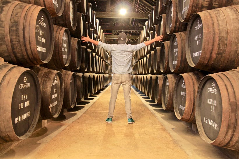 top wineries in door county, man standing amidst wine barrels with his arms outstretched
