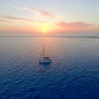 boat hitch hiking, catamaran on the ocean at sunset, discover the world, sailing blog