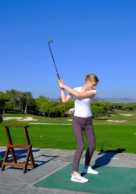 a woman playing golf in algarve