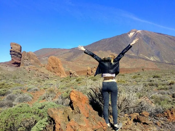 best things to do in Tenerife North, back of person throwing up arms in excitement with Mount Teide in distance
