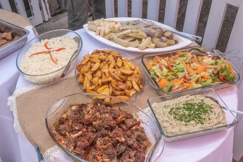 Find out what is there to do in sal cape verde, table covered in plates of different foods including seasoned white rice, fried potato wedges, spiced dip, meat off the bone and mixed vegetables