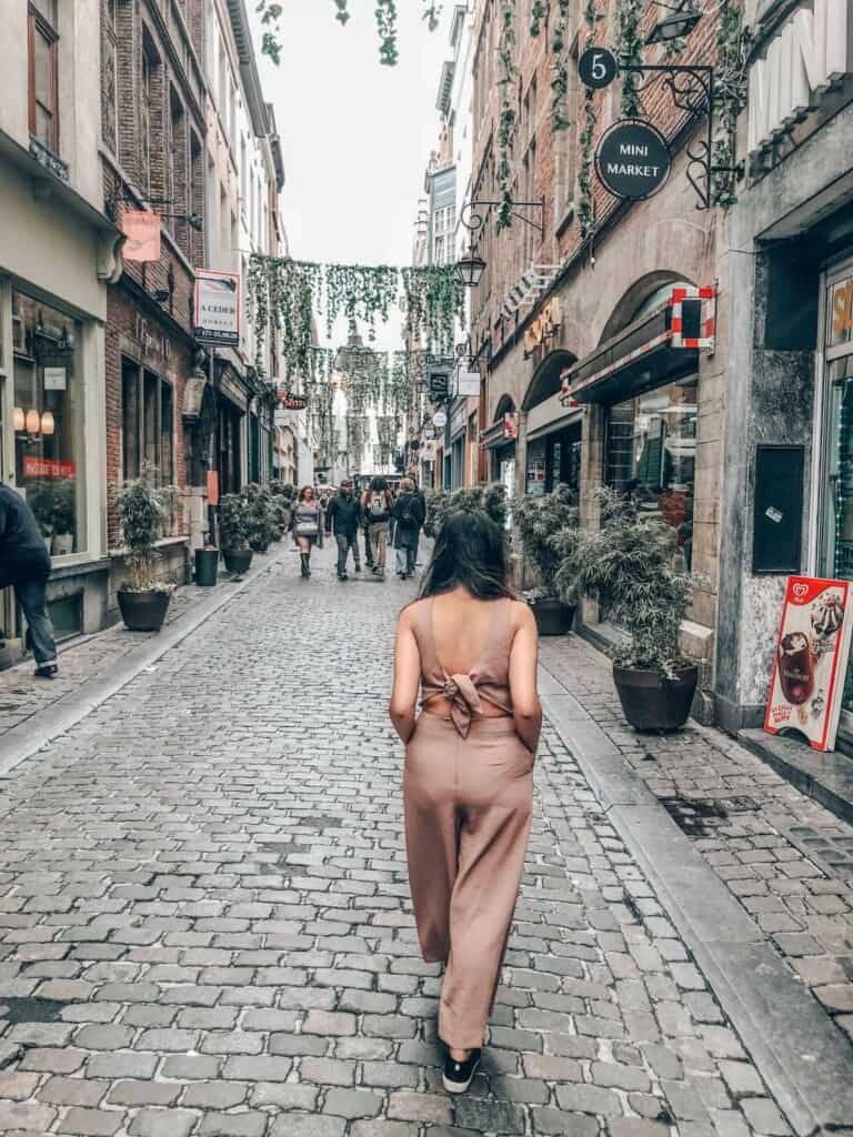 a girl walking through a scenic street in brussels, belgium