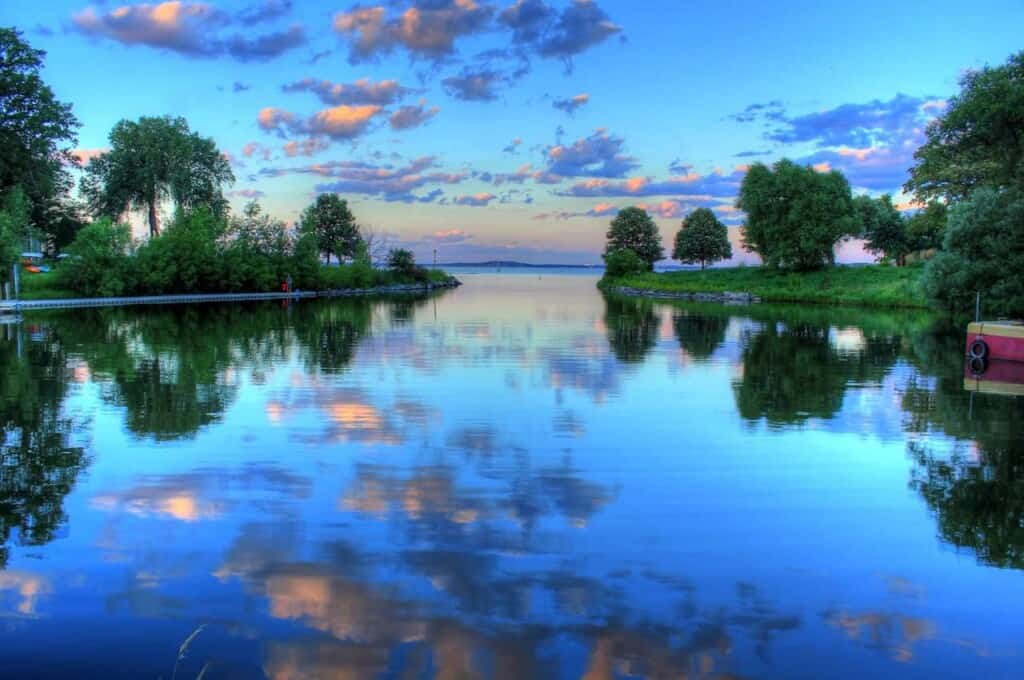 a view of a lake with a few trees during a sunset