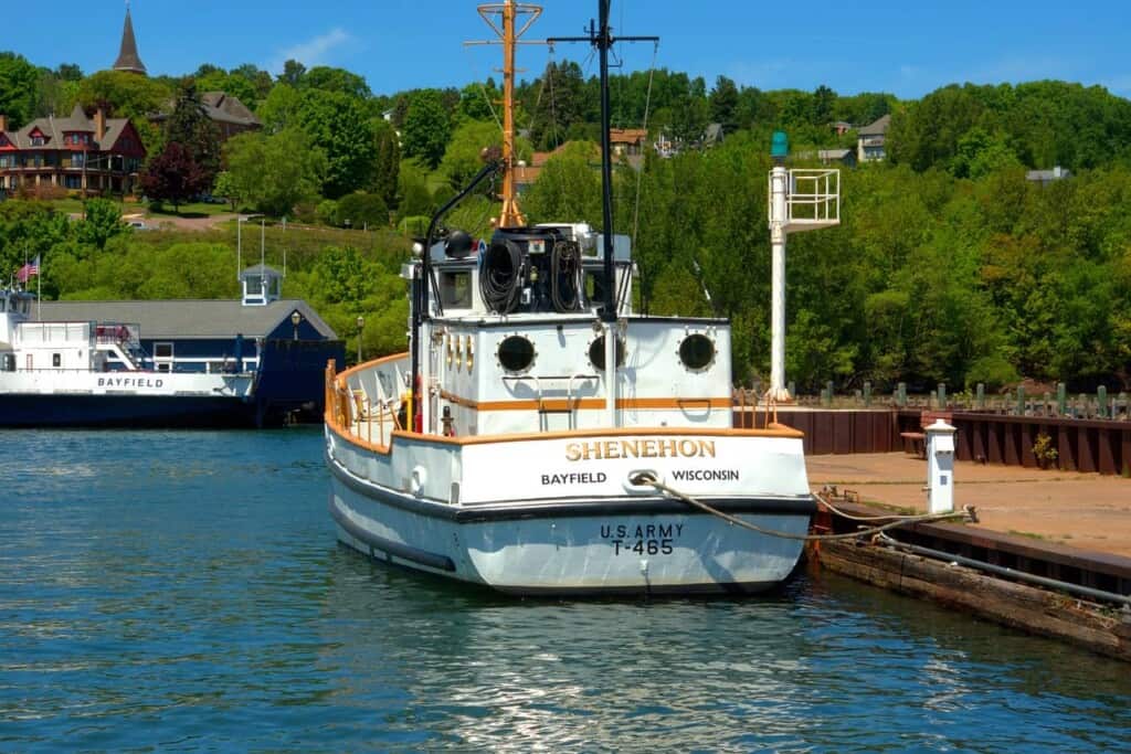 boats docked in a small pier with trees at the back