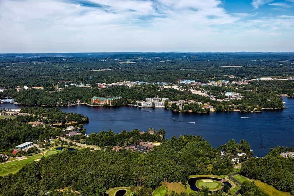 aerial view over wisconsin dells with a lake, trees, and houses