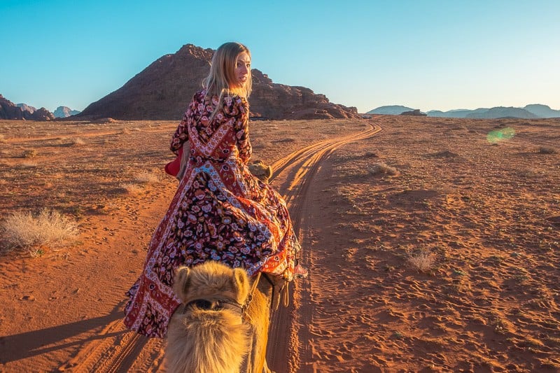 Find your favourite Wadi Rum quotes, Paulina riding camel along track through the desert at sunset