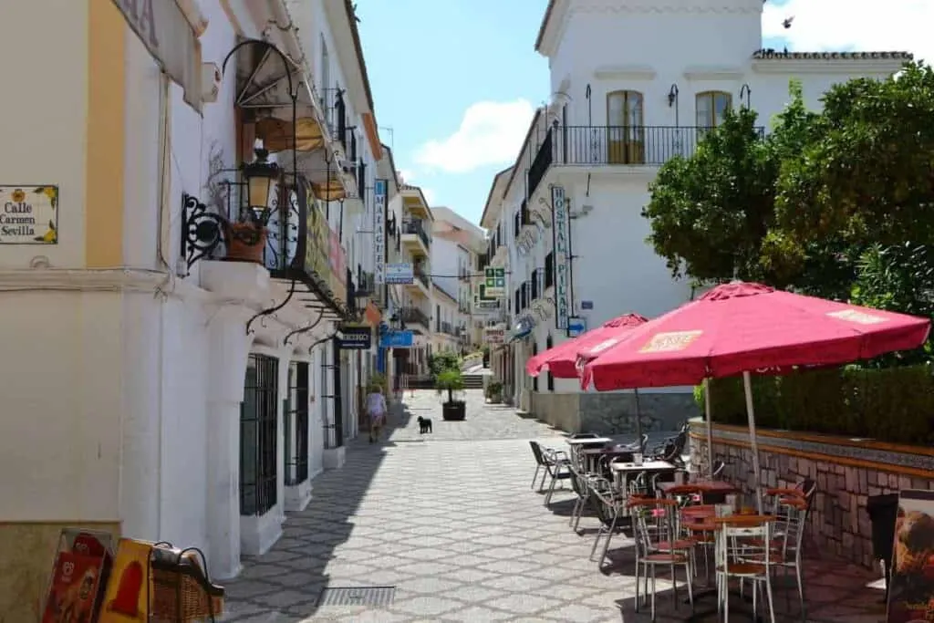 cost of living in tenerife, empty street in Estepona Tenerife full of little shops and businesses with cafe and outdoor seating at forefront