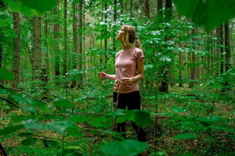 girl hiking in bialowieza forest surrounded by trees and plants