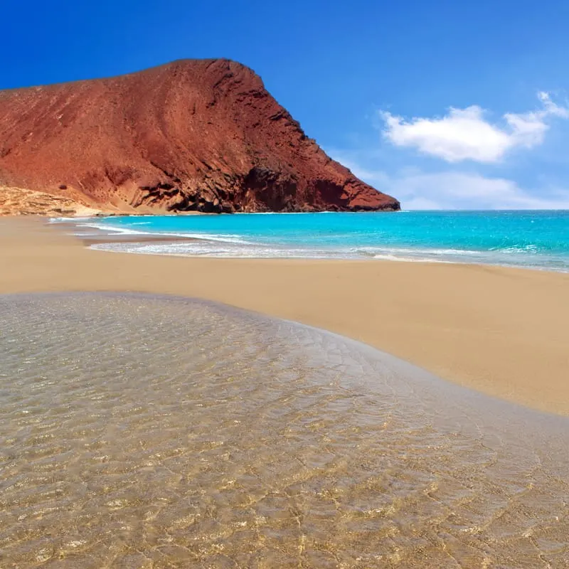 sandy south tenerife beaches, Beach Playa de la Tejita turquoise in Tenerife Canary islands with red mountain