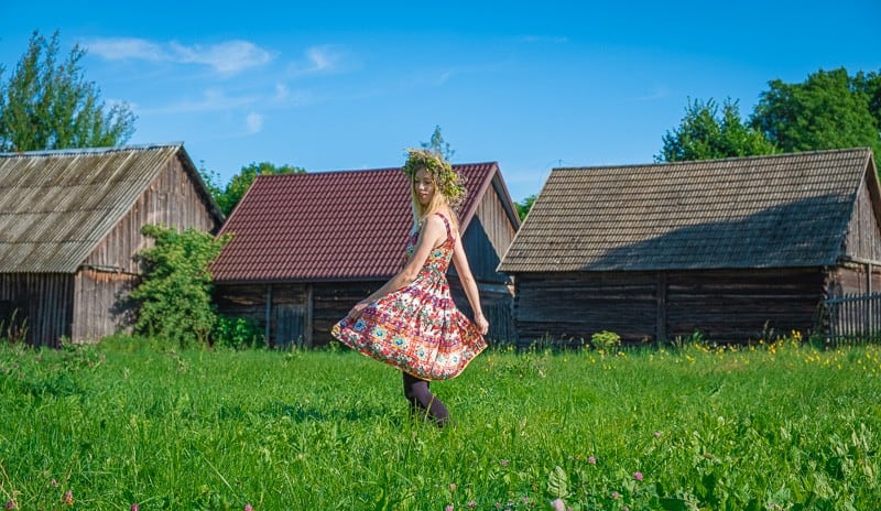 travel blogger in poland in the grass dancing