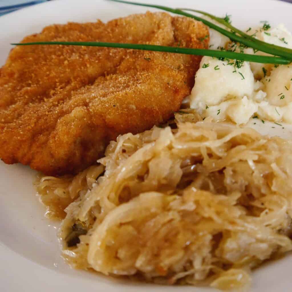 Best Polish Food A polish pork cutlet served with pocked cabbage and purred potatoes on a plate