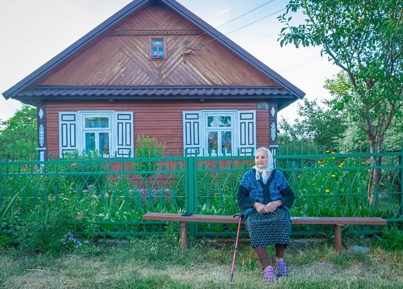 old lady in poland in front of a traditional house in podlasie