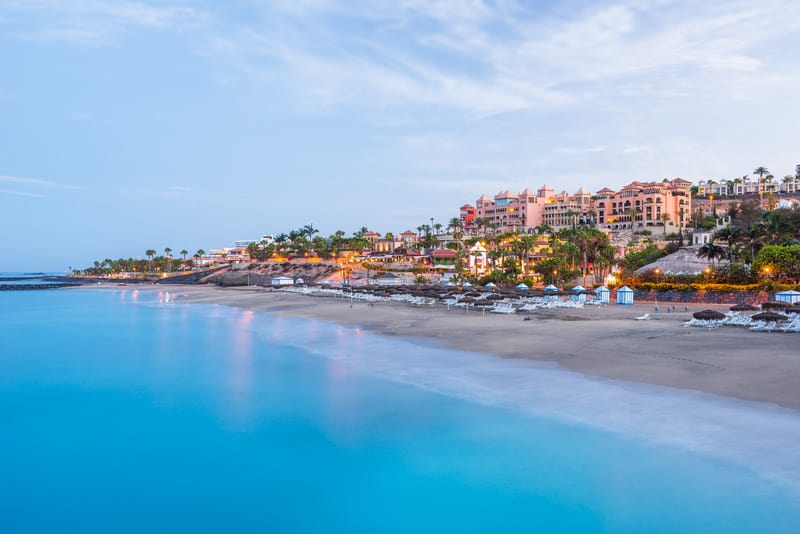 best beaches in Costa Adeje, sandy beach next to city in Tenerife lit up at dawn