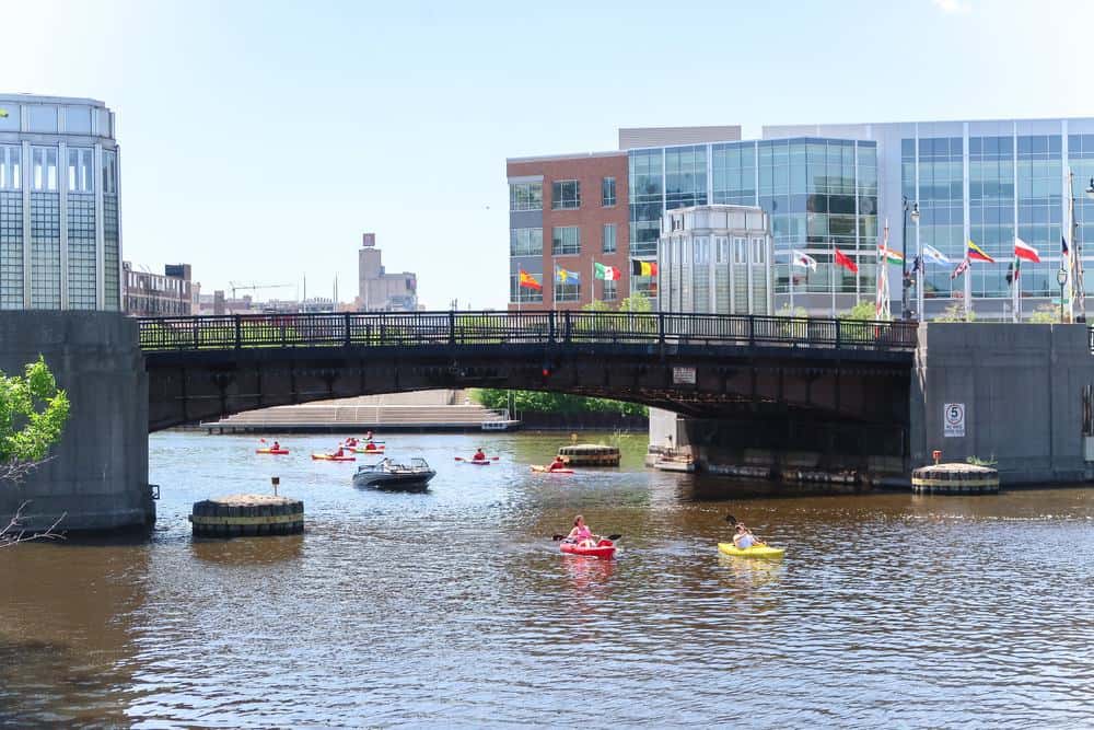 where to stay in milwaukee downtown, wisconsin, people kayaking under a bridge on the water of the Milwaukee River downtown