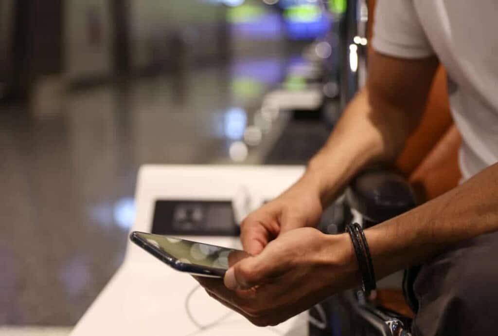 How does an eSim for Europe work? Man using public phone charging station at the airport