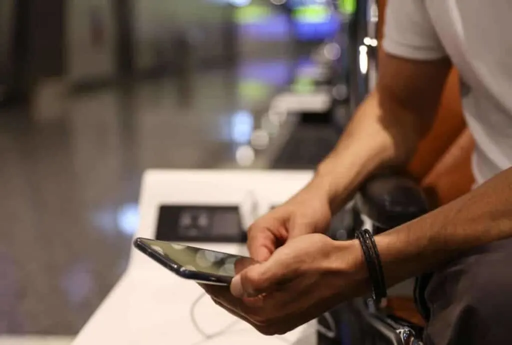 Stay connected during your travel and flight, Man using public phone charging station at the airport