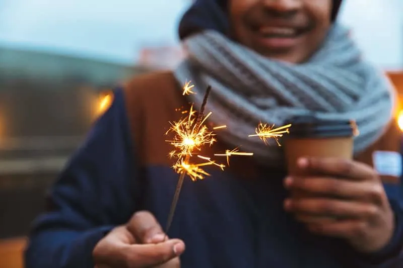 fun things to do in winter in milwaukee, Cropped image of an african young man standing posing outdoors winter oncept drinking coffee holding bengal lights.