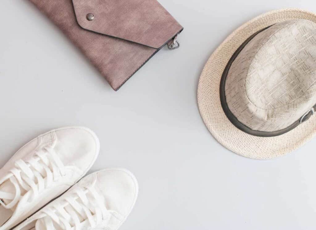 Flat lay travel items - shoes, hat and purse on grey background, Cheap Flights on Kayak
